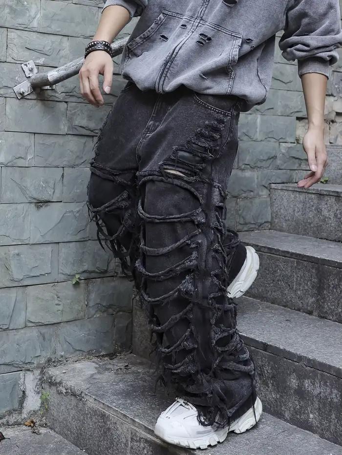 Jean noir pour hommes. Avec un design de (trous ébouriffés) et des pompons. Dans un style tendance de rue.